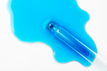 Drops of cosmetics and a pipette on a white background. A product for skin, face or hair care.