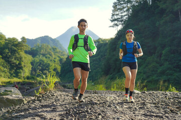 Asian Indonesian couple trail running near Merapi volcano, active sport and sustainable lifestyle