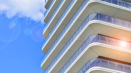 Exterior of a high modern multi-story apartment building - facade, windows and balconies. Modern...