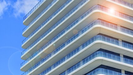 Exterior of a high modern multi-story apartment building - facade, windows and balconies. Modern...