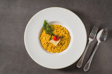 Porcini mushroom risotto on a white porcelain plate on a stone table