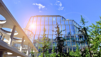 Sustainable glass office building with trees for reducing carbon dioxide. Eco-friendly building in...