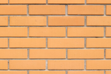 Obraz premium Brick wall texture, background. Orange brick wall background for exterior design. Construction concept, outdoor buildings, garage or house. Wall with classic checkerboard pattern and visible joints