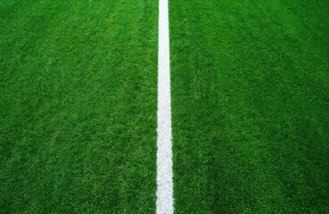 Artificial green grass soccer field with white line shot from above. Sport concept background for american football, rugby, baseball. Lawn texture pattern for sports, design backdrop.