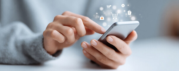 Hands holding phone, shopping icons above. Concept for online shopping, mobile commerce, ecommerce. Suitable for advertising, blog, or business.