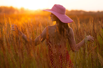 Woman in a hat of the high meadow grass.