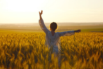 Young woman among rye field in the evening.
