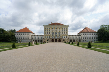 Naklejka premium Historic palace with elegant architecture and serene gardens in a tranquil setting on a cloudy day