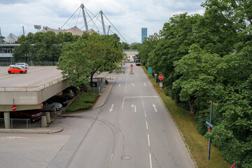 Empty street in a park area with trees and buildings in the background during an overcast day