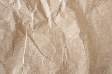 Brown crumpled paper texture or background for design with copy space for text, top view. Packaging material.