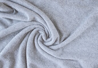 Cashmere gray fabric, top view. Draped, texture, background. Natural wool clothing.