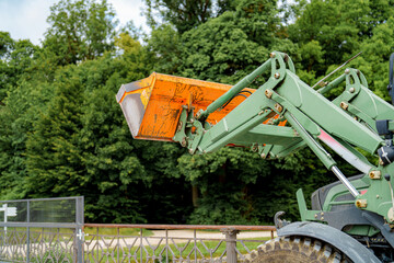 Heavy machinery prepares for landscaping work in a lush green environment during daylight hours