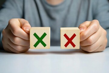 Hands hold wooden blocks, one with a green checkmark, the other with a red x.  Decision making, choice, options