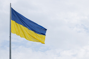 flagpole blue yellow Ukrainian national sign waving on a wing neutral sky background poster concept with advertising copy space for Independence day