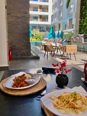 lunch on the terrace in an apartment overlooking the relaxation area and pool, summer holidays, property rentals, lifestyle concept. High quality photo