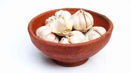 Close up of raw garlics on wooden bowl. top view. isolated white	
