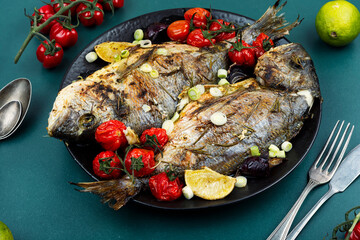 Grilled dorado fish with lemon, rosemary and vegetables.