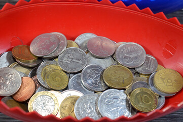 collection of different coins from multiple countries around the world in an egg shaped money coin...