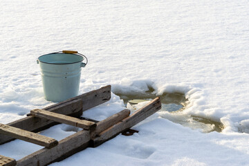 Naklejka premium Empty bucket stands at ice hole.