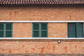 Fototapeta na wymiar Red brick building with green windows