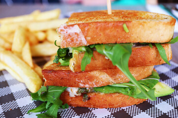 Closeup of mouthwatering chicken avocado and arugula salad sandwich