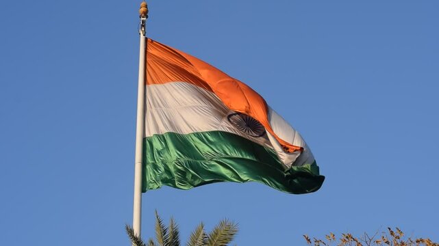 India flag flying high at Connaught Place with pride with plain white background, India flag fluttering, Indian Flag on Independence Day and Republic Day of India, tilt up shot, Har Ghar Tiranga
