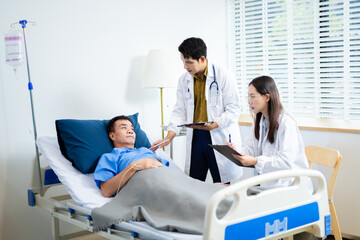 Doctor and nurse consult senior patient in hospital bed, discussing medicine & treatment. Caring...