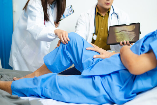 Doctors assess senior patient’s knee injury with care and teamwork in hospital.