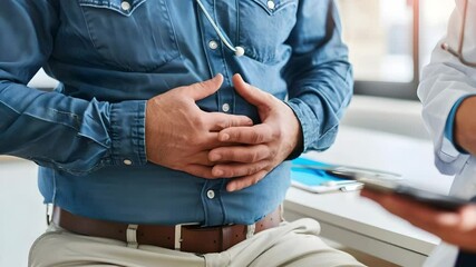 Man holding stomach pain and discomfort during medical consultation with doctor in clinic office showing concern and care