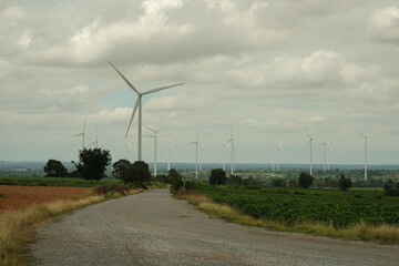 Wind turbines generating clean energy in a rural landscape, symbolizing sustainable development and...