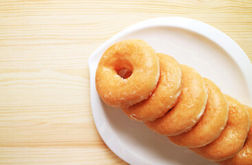 Plate of Delectable Sugar Glazed Doughnuts on Wooden Background