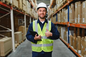 Warehouse worker checking his list on clipboard in a large warehouse
