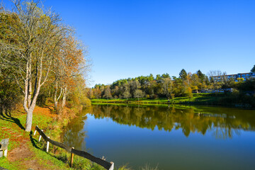 Landscape at the Gerolstein reservoir in autumn. Idyllic nature at the lake in the Eifel region.
