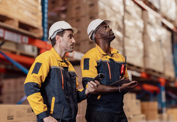 Warehouse manager, store inspector checking stock on storage shelf from inventory checklist. Two...