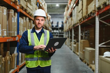 Worker with laptop computer in mail order warehouse