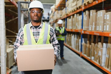 Portrait of a handsome african american warehouse worker in overalls and a helmet