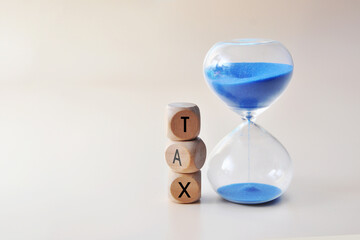 The word "tax" and an hourglass, representing the concept of paying taxes and submitting tax reports