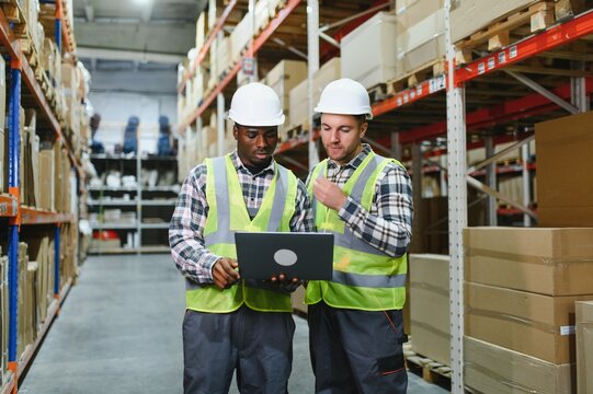 Two warehouse workers checking and controlling boxes in warehouse, Professional warehouse workers