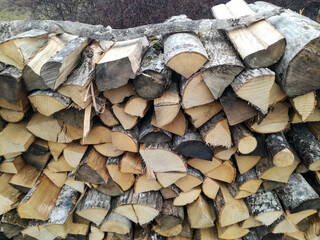 Woodpile. Chopped firewood is stacked in neat piles. Natural energy raw material. Background. Close-up. Selective focus.