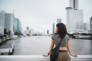 Solo southeast asian woman teenager blogger express thoughtful wait for local boat. world travel explorer cultural experience on Chao Phraya river. Asia tourism concept in Bangkok Thailand
