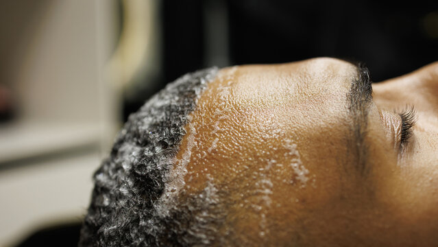 Close up of shampoo on hair of african american client in barbershop - Powered by Adobe