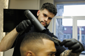 Barber drying hair of african american client 
