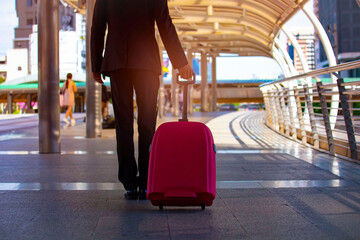 Business Man Walking With Luggage in the Airport. as photo of unrecognizable businessman in black suit walking through airport terminal