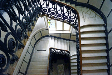Architecture of historical houses in Belgrade, Serbia: staircase in the Museum of Applied Arts. View from the landing down to the entrance with a marble staircase and openwork wrought iron railings