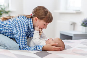 Older sister playing lovingly with baby sibling