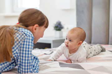 Baby care. Baby making eye contact with big sister.