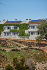 Modern eco-friendly apartments with solar panels in coastal Mediterranean town