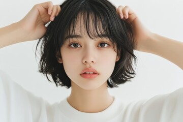 Young woman touching her hair and looking at camera