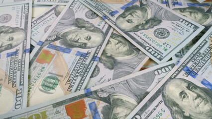 A visually appealing background of stacked hundred dollar bills symbolizes wealth and prosperity