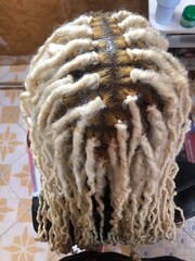 Nairobi, Kenya - July 3, 2025: Close-up top view of professionally styled blonde faux locs on a...